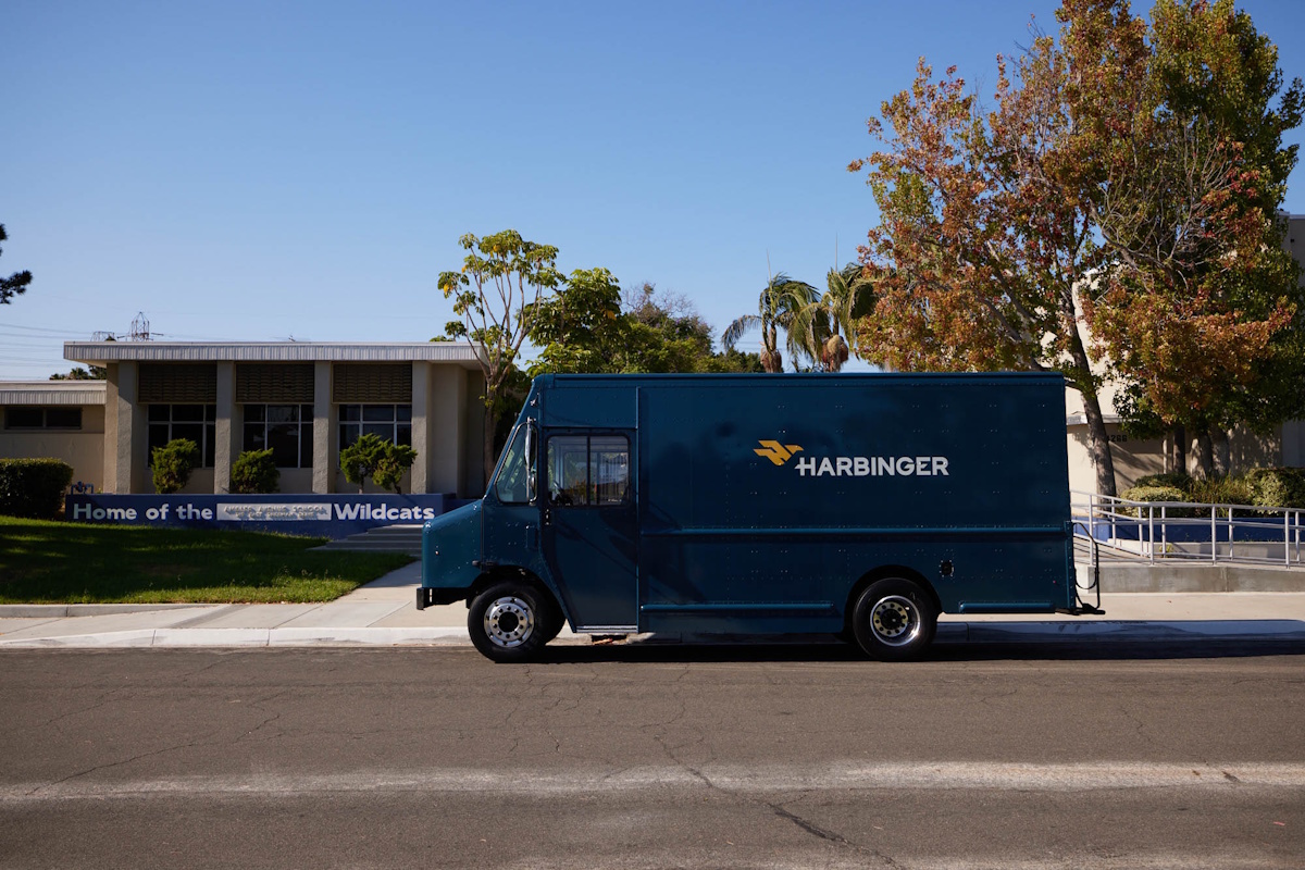 A Harbinger EV parked on the side of a street.