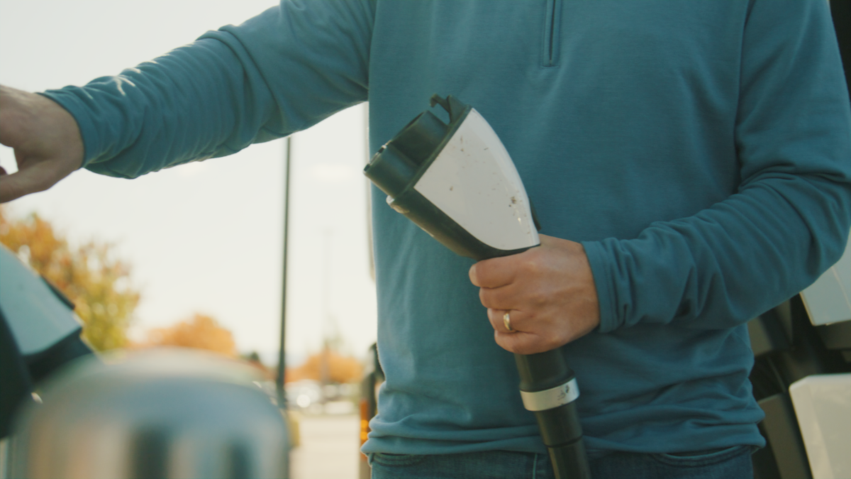 A person holding an electric vehicle charging cable.