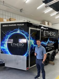 An engineer poses in front of a newly designed mobile charging trailer