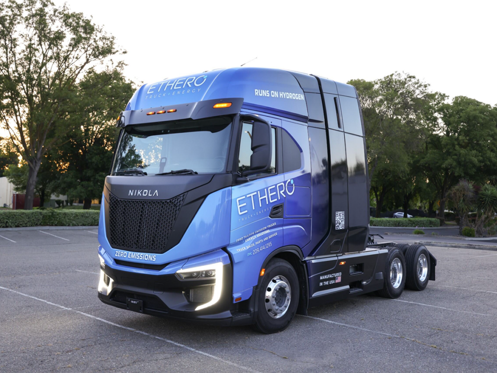 A blue electric heavy duty truck wrapped with ETHERO Truck + Energy branding