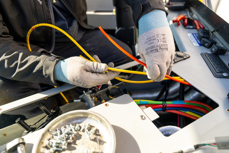 A worker handing wires coming out of a console