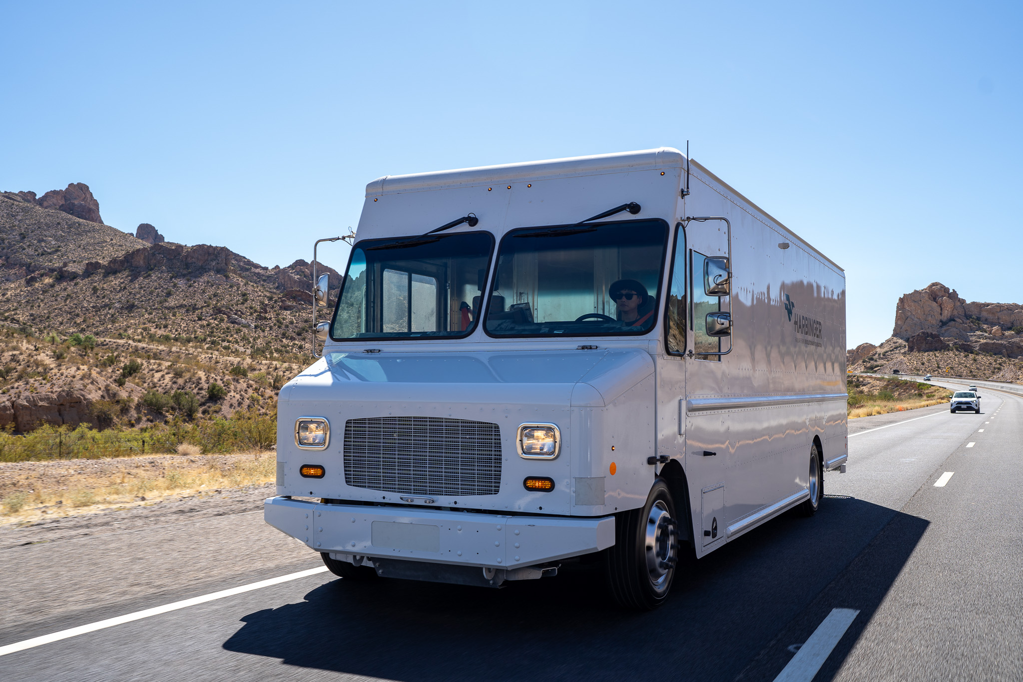 A white Harbinger truck driving on a road